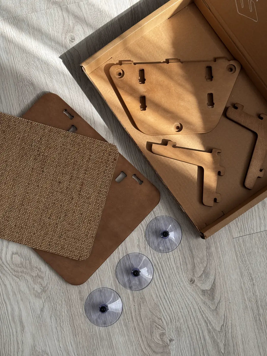 Wooden parts, two sisal pads and three suction cups laid out on the floor